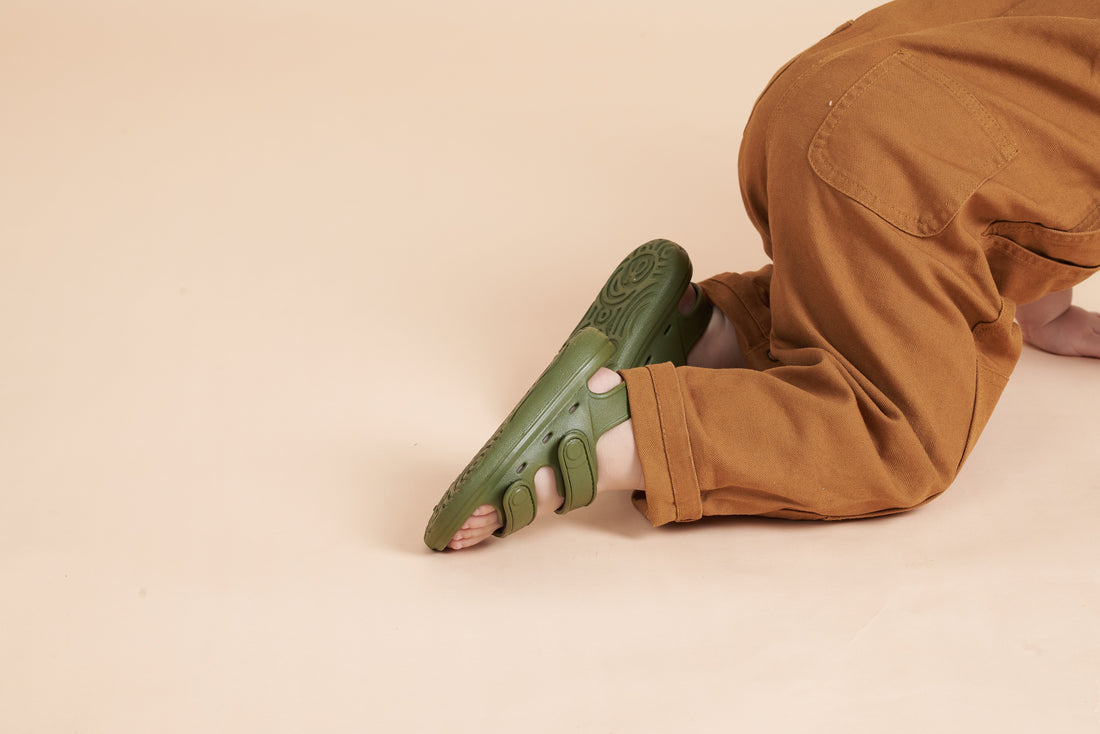 Close-up of the underside of an olive green Wonderskips sandal, highlighting the high-traction, patterned rubber sole.