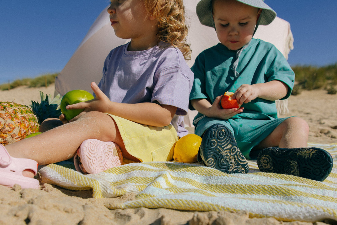 Detailed view of the patterned, non-slip soles of pink and navy Wonderskips sandals during a beach picnic.
