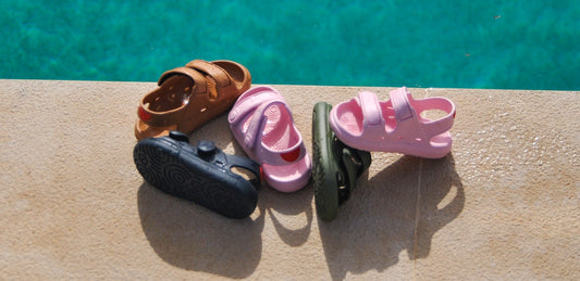 Overhead view of Wonderskips kids' waterproof sandals on a stone poolside ledge.