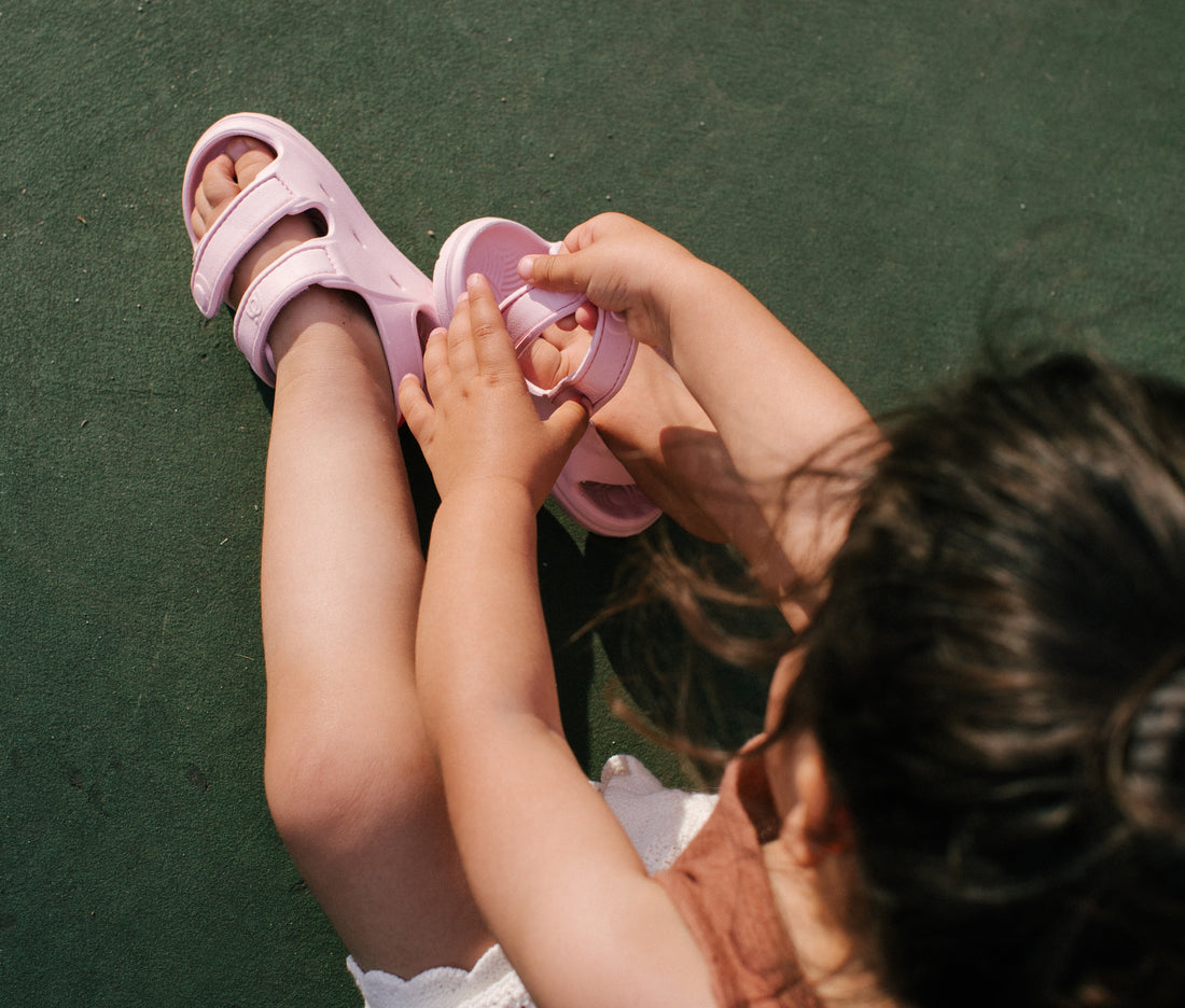 Toddler putting on wonderskip sandals 