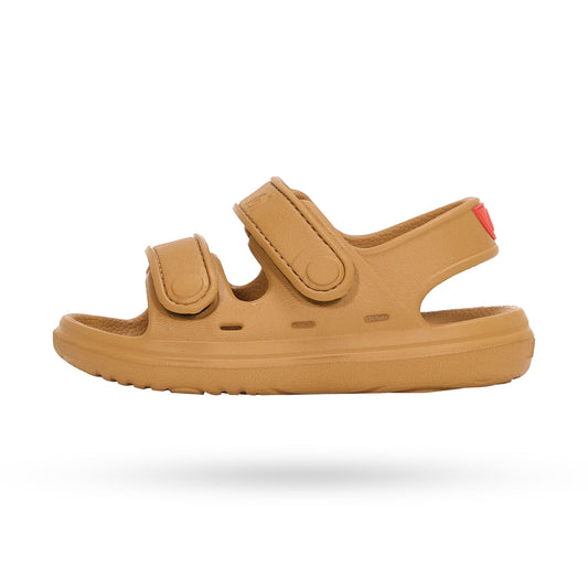 Studio product shot of a tan Wonderskips sandal with a red heel accent, showcasing the sleek, waterproof double-strap design.